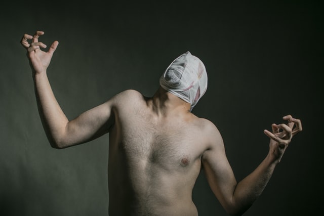 naked man with bandages on his head