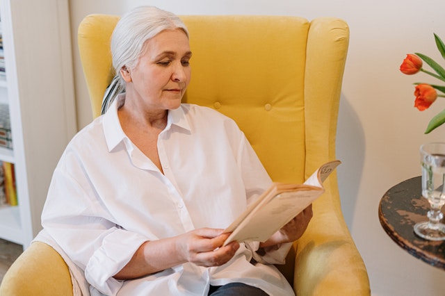 old woman sitting on yellow couch